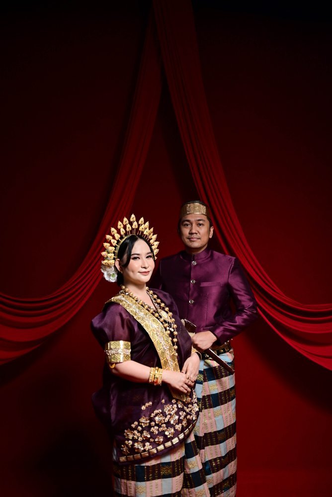 Iwan dan Yuli berdiri bersama di depan tirai merah
